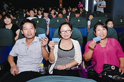 来深建设者手持“爱心卡”开心看电影。深圳侨报记者 钟致棠 摄